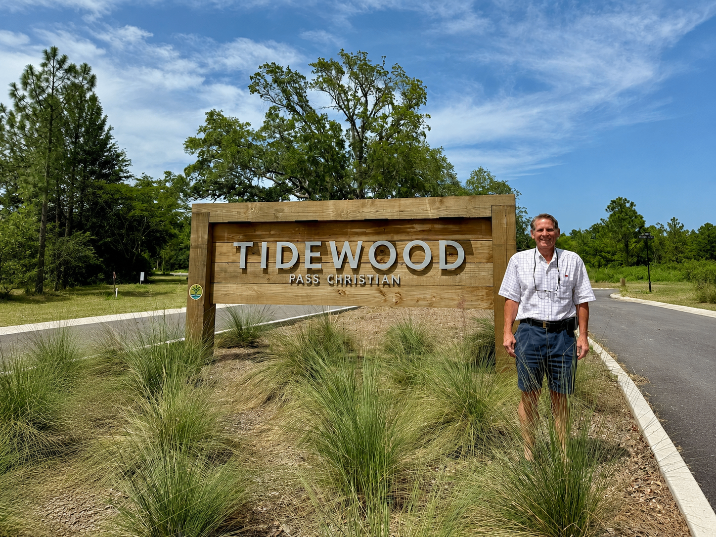 Former Pass Christian Mayor Jimmy Rafferty standing beside the Tidewood community entrance sign in Henderson Point.